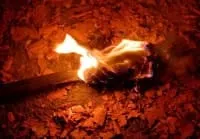 A blazing forge with bright flames and glowing embers, showcasing traditional metalworking techniques.