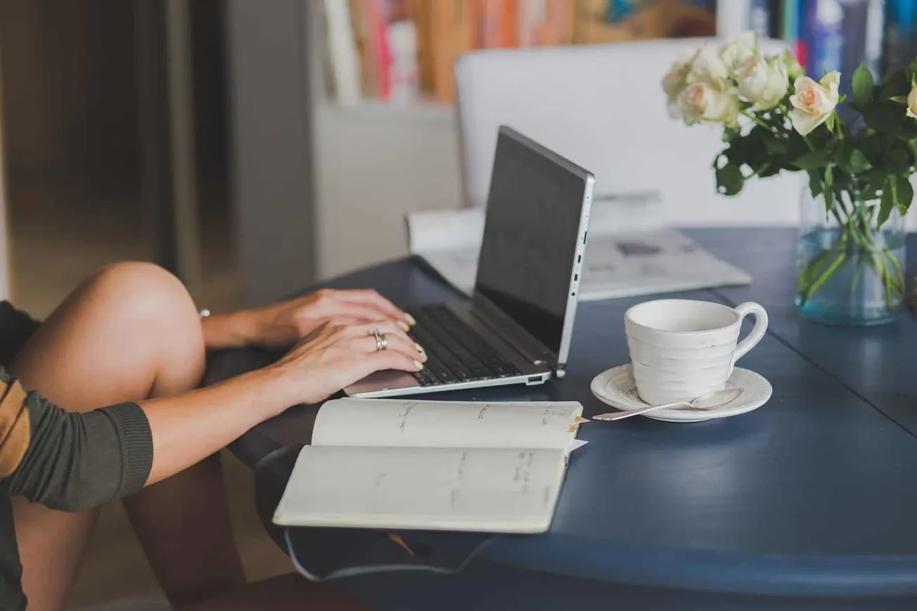 Laptop work setup with coffee and flowers, modern home office, productive workspace, cozy environment for remote work, focuse